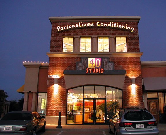 Exterior of 4.0 Studio personal training center at night with Personalized Conditioning sign