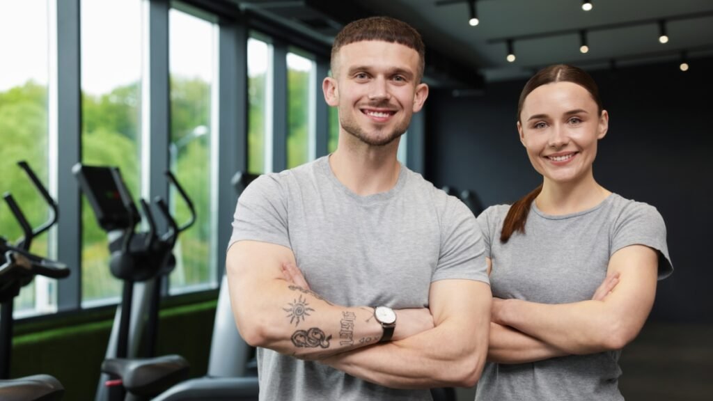 Two personal trainers standing in a gym, representing building a personal training business and studio ownership